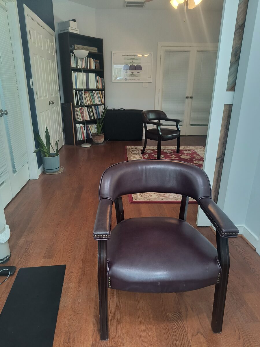 A calm coaching space at Apex NeuroCare with a comfortable chair and bookshelves